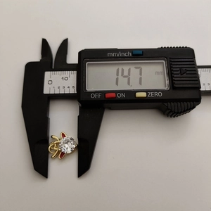 Macro view showing 14.7mm measurement of a zircon elk pendant with red enamel details