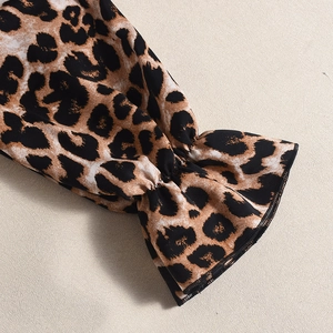 Close-up of leopard print flare sleeve cuff and polyester fabric detail on the dress