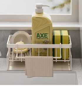 Kitchen sink organizer for sponges and soap with a white metal rack and towel bar