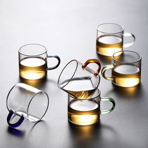 Heat-resistant borosilicate glass teacups with colorful handles on a dark background