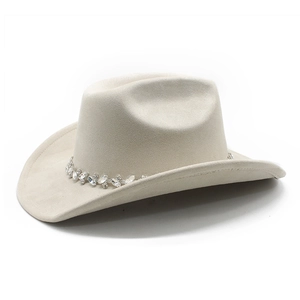 Close-up of beige suede cowboy hat featuring a sparkling rhinestone-embellished hat band
