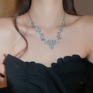 Close-up of silver-plated leaf and flower pendant necklace set with sparkling rhinestones