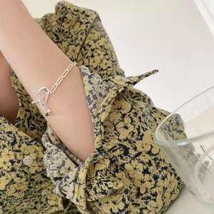 925 silver chain bracelet with T-bar clasp and green gemstone charm on a model's wrist