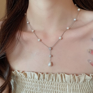 Detail of elegant Y-shaped necklace with zircon flowers and water drop pearl pendant