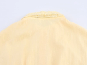 Détail de l'encolure en dentelle sur une robe chemise texturée de couleur jaune clair