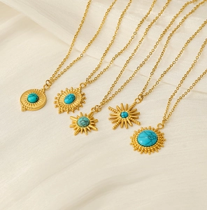 Detailed view of bohemian gold necklaces with turquoise pendants on white silk background