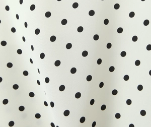 Close-up detail of white fabric with black polka dots and fine textile texture for dresses
