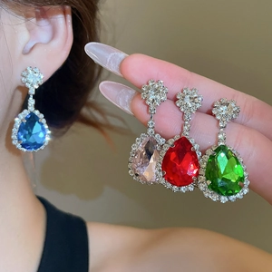 Detailed view of silver needle teardrop earrings with crystals in four vibrant colors