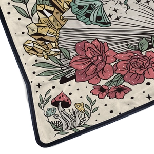 Close-up of flannel blanket with vibrant butterfly, floral, and mushroom pattern detail