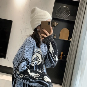 Winter outfit detail featuring a cozy white rabbit hair knit hat and patterned sweater
