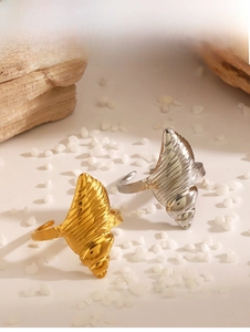 Detailed view of conch shell shaped stainless steel rings in gold and silver finishes