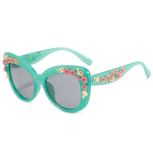 Baroque style cat eye sunglasses in mint green with floral decorations and grey lenses