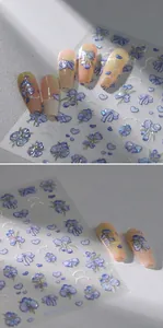 Macro shot of 3D embossed nail stickers featuring blue bows and heart designs