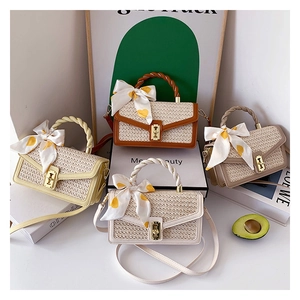 Detailed view of four straw crossbody bags with twist handles and polka dot scarves