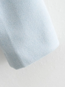 Détail du tissu en tweed bleu clair montrant la texture fine de laine et le tissage