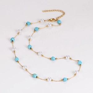 Dettaglio della collana a catena dorata con perle turchesi, perle bianche e catenina