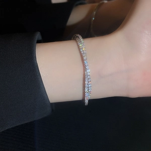 Close-up of a double-layer crisscross silver bracelet with pavé cubic zirconia on model