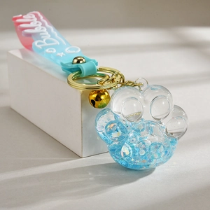 Luminous cat paw oil liquid keychain with blue sequins and golden bell pendant