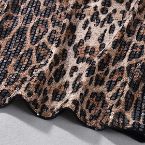 Gros plan sur le tissu à paillettes imprimé léopard avec détails de broderie marron