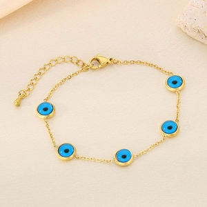 Détail d'un bracelet en acier inoxydable doré orné de cinq breloques œil bleu