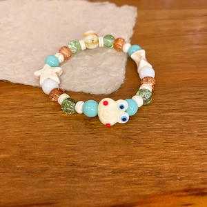 Macro shot of colorful ceramic beads bracelet with star and animal face charms