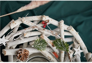 Detail of Christmas wreath with white wood, pine cones, green needles and red berries