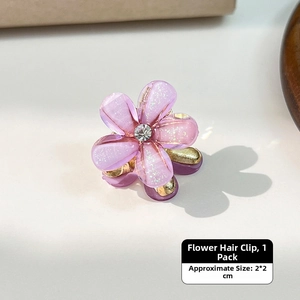 Macro detail of a 2x2cm purple flower hair claw clip with glitter finish and rhinestone