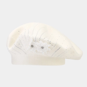 Detailed knit texture of a beige beret featuring 3D flowers and sparkling rhinestones