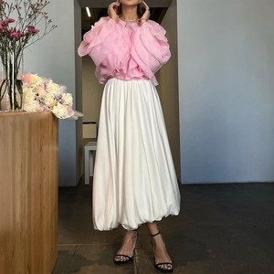 Detail van roze geplooide ruffletop met een witte satijnen A-lijn vloeiende maxi-rok