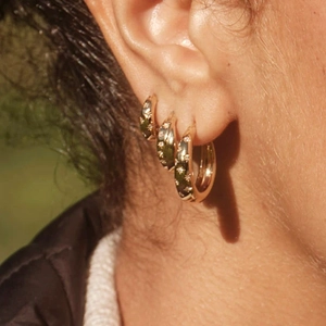 Close-up of gold S925 sterling silver hoop earrings with star texture on a model's ear
