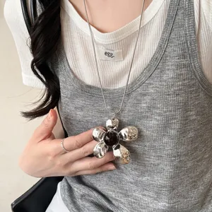 Metallic liquid-style flower pendant necklace with dark gemstone and sleek snake chain
