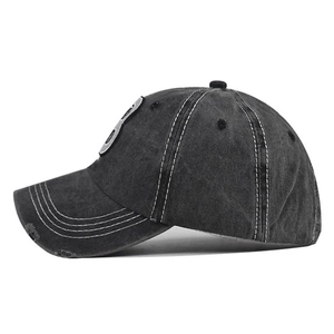Detail of washed cotton baseball cap with star embroidery and distressed brim edge