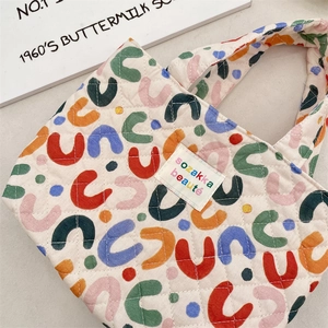 Détail du sac cabas en coton matelassé avec motifs en U colorés et étiquette tissée