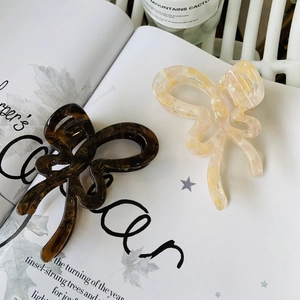 Detail of tortoise and cream butterfly hair claws on a vintage book backdrop