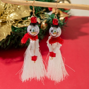 Detail of Christmas snowman earrings with white tassels and festive red beads hooks