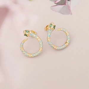 Close-up of golden snake earring with blue enamel scales and sparkling zircon accents