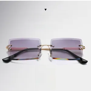 Detail of rimless square sunglasses with gradient grey lenses and gold metal temples