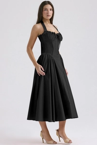 Close-up of elegant black halter neck dress with waist pleats and flowing fabric detail