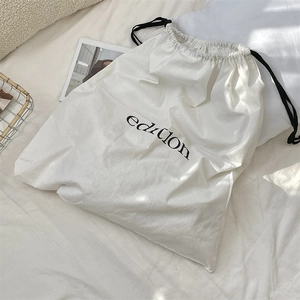 Close-up of cotton linen drawstring bag with black edition print on white fabric