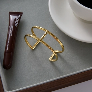 Detail of 18K gold stainless steel open bangle featuring double-layer hammered texture
