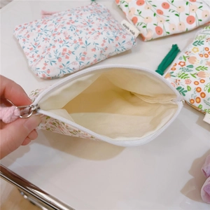 Detail of floral cotton pouch showing interior lining and smooth zipper closure