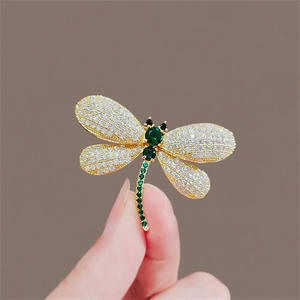 Exquisite dragonfly brooch featuring sparkling rhinestones and green gems, perfect for chic outfits.