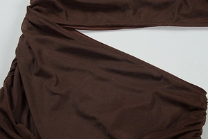 Detail of dark brown ribbed fabric with elegant ruching and fine stitching craftsmanship