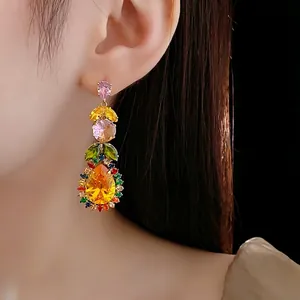 Luxury drop earrings featuring colorful leaf stones and large yellow pear-cut crystals