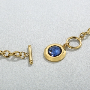 Macro shot of gold OT toggle clasp and blue faceted crystal pendant on a link chain