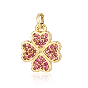 Macro detail of a gold clover pendant set with sparkling pink zircons and an eye motif