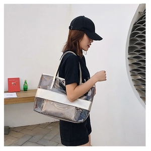 Detail of transparent PVC beach bag with silver metallic trim and long shoulder straps