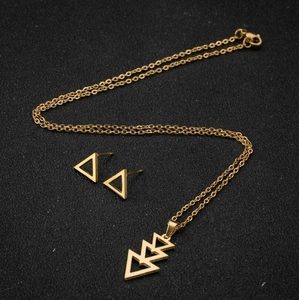 Détail de l'ensemble collier et boucles d'oreilles triangle doré sur fond noir