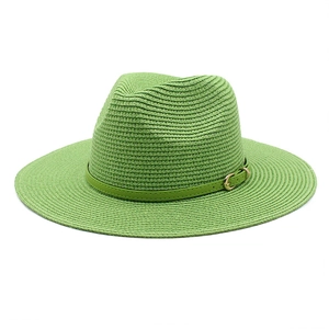 Detailed macro view of woven grass green sun hat texture with gold metallic buckle
