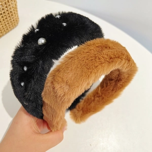 Detailed view of plush faux fur headbands in black with pearls and caramel color